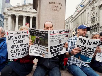 People on street against buildings in city