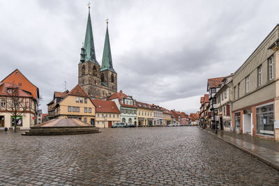 Street amidst buildings in town against sky