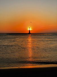 Scenic view of sea against orange sky