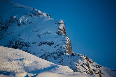 Scenic view of snowcapped mountains against clear blue sky