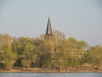 View of castle by trees against clear sky