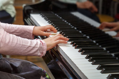 Cropped hand of woman playing piano