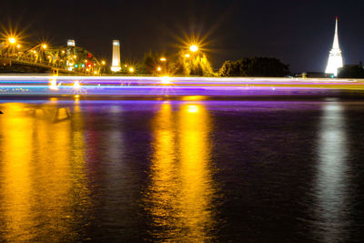 Light trails on street by river at night