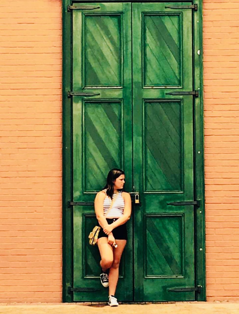 FULL LENGTH OF WOMAN STANDING AT ENTRANCE OF CLOSED DOOR