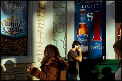 Woman with text on wall in city at night