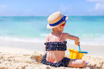 Midsection of woman wearing hat on beach