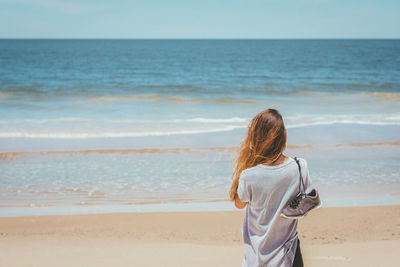 Blond girl contemplating the sea