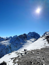 Scenic view of snowcapped mountains against clear blue sky