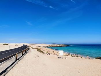 Scenic view of beach against clear blue sky