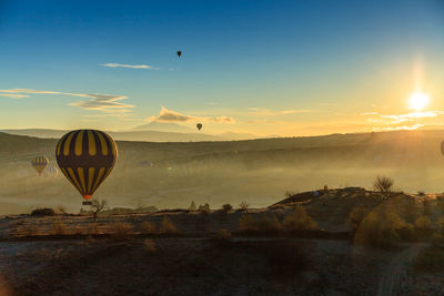 Hot air balloon flying against sky during sunset