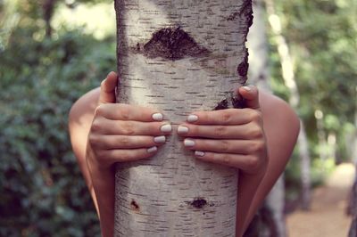 Woman holding tree trunk