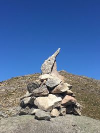 Stack of rocks against clear blue sky