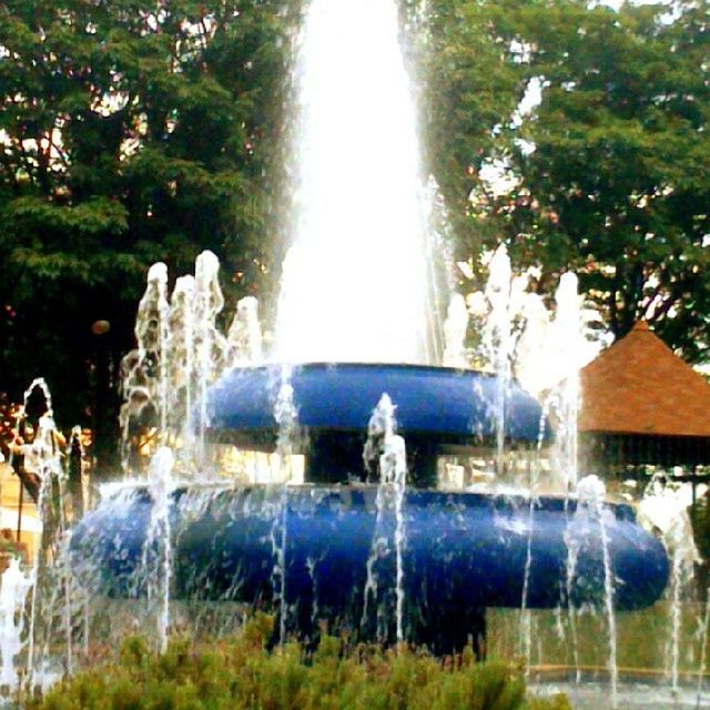 fountain, water, motion, splashing, spraying, tree, long exposure, park - man made space, waterfall, flowing water, nature, beauty in nature, waterfront, flowing, day, sculpture, travel destinations, outdoors, blurred motion, scenics