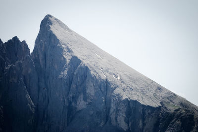 Low angle view of rocky mountains against clear sky