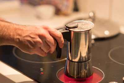 Close-up of man pouring coffee in cafe