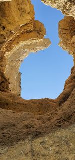 Low angle view of rock formations against clear blue sky