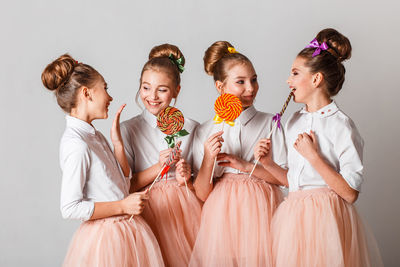 Girls having colorful lollipops against white background