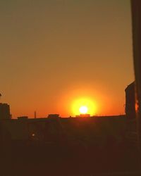 Silhouette buildings against clear sky during sunset