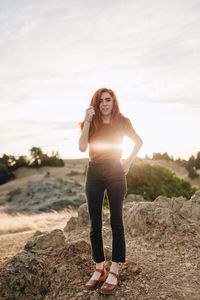 Portrait of young woman standing on rock