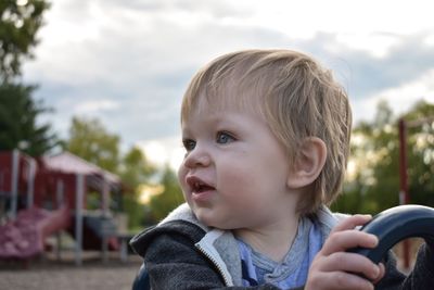 Close-up of baby boy against sky