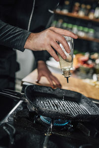 Restaurant cooking - chef pouring oil into a pan