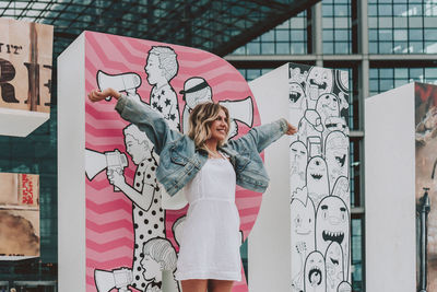 Woman standing against graffiti wall