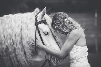 Young woman holding white horse