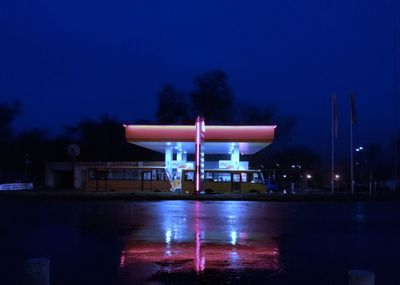 Illuminated built structure against blue sky at night