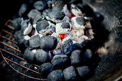 Closeup of glowing coal in metal grill on summer day in the garden