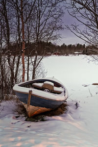 Boat moored in lake during winter