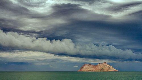 Scenic view of sea against storm clouds