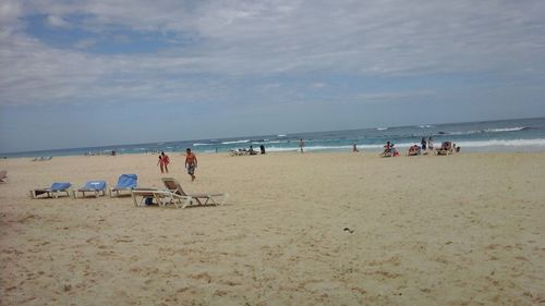 People at beach against sky