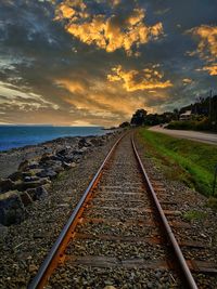 View of railroad tracks against sky during sunset