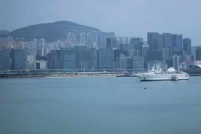 Modern buildings by sea against sky in city
