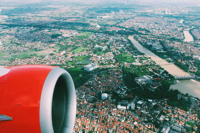 Close-up of airplane flying over river in city