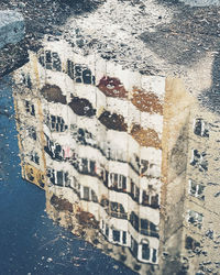 High angle view of buildings seen through wet window