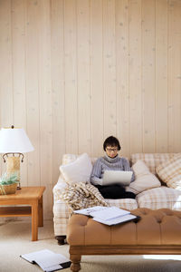 Senior woman using laptop in living room at home