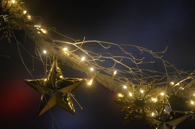 Low angle view of illuminated christmas tree against sky at night