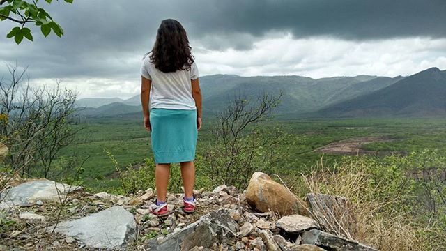 mountain, sky, rear view, cloud - sky, tranquil scene, lifestyles, leisure activity, tranquility, landscape, standing, full length, casual clothing, scenics, beauty in nature, nature, rock - object, cloud, person