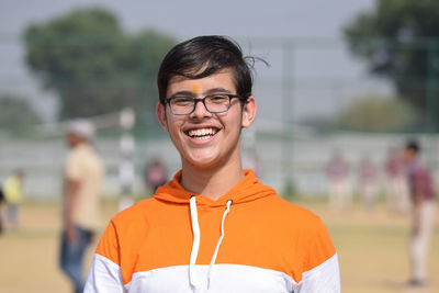 Portrait of young woman standing on soccer field