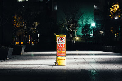 Information sign on street in city at night