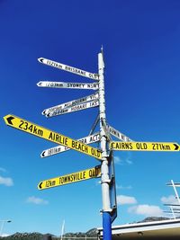 Low angle view of road sign against blue sky