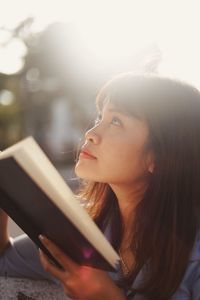 Close-up of woman holding book outdoors