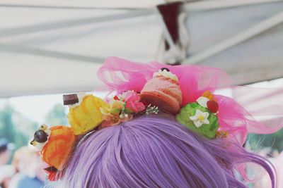 Close-up of artificial ice cream headwear on mannequin head with purple wig