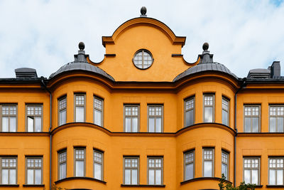 Low angle view of yellow building against sky