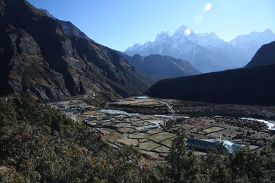 High angle view of buildings by mountains against sky