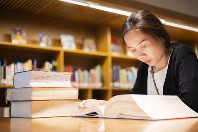 Close-up of woman reading book at table