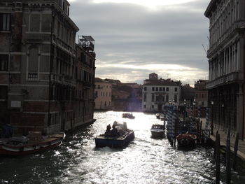 Canal in city against sky