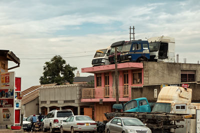 Cars on road in city against sky