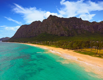 Scenic view of sea and mountains against sky